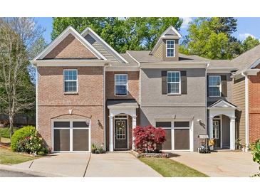 Charming townhome with brick and gray siding, attached garages, and well-maintained landscaping at 5260 Sherwood Way, Cumming, GA 30040