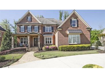 Charming two-story brick home with a manicured lawn, stone accents, and classic architectural details at 2331 Kinsale Nw Pt, Kennesaw, GA 30152