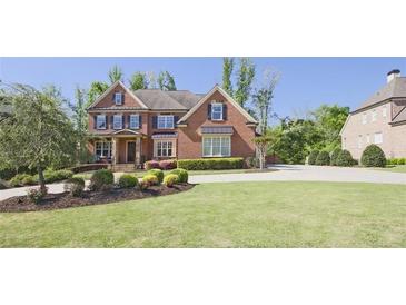 Spacious front yard with a large lawn and a beautifully landscaped garden leading up to the brick home at 2331 Kinsale Nw Pt, Kennesaw, GA 30152