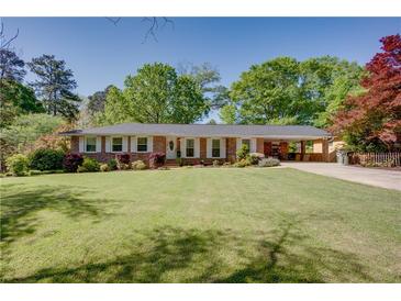 Charming brick home with a lush green lawn, mature trees, and well-maintained landscaping at 3397 Old Jonesboro Rd, Hapeville, GA 30354