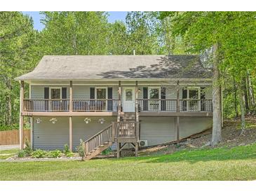 Charming two-story home featuring a cozy front porch, wood railings, and a well-maintained landscaped yard at 1206 Parkwood Chase, Acworth, GA 30102