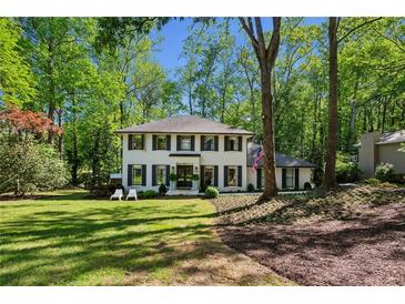 Charming two-story home with a landscaped yard and a classic white facade, surrounded by mature trees at 4505 Glengary Ne Dr, Atlanta, GA 30342