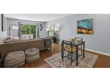 Cozy living room featuring a comfortable sofa, stylish rug, and a small dining table at 5400 Roswell Rd # H5, Atlanta, GA 30342