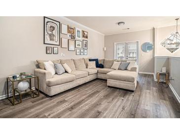 Spacious living room features a large sectional sofa, hardwood floors, and stylish wall art at 1137 Liberty Nw Pkwy, Atlanta, GA 30318