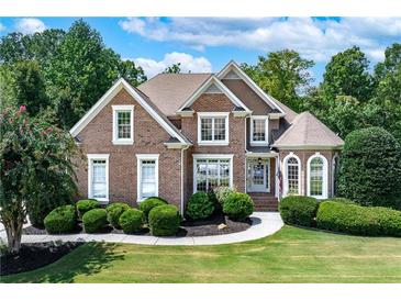 Beautiful brick home with manicured lawn and lush landscaping at 226 Crescent Moon Way, Canton, GA 30114