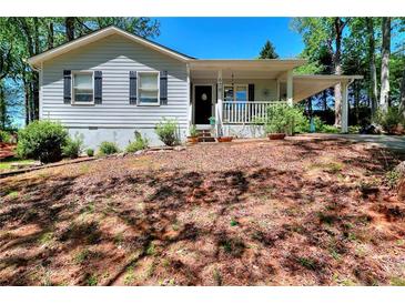 Quaint home with a charming front porch, cozy curb appeal, and a lush yard at 679 Suwanee Ct, Lawrenceville, GA 30043