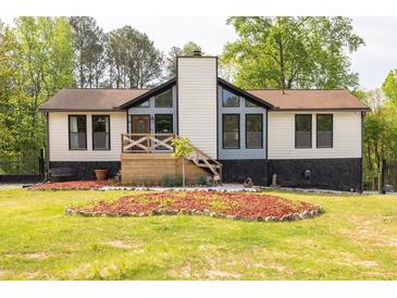 Charming home exterior featuring a quaint front porch, black trim, and a well-manicured lawn at 2619 Kellogg Creek Rd, Acworth, GA 30102