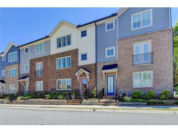A row of stylish townhouses shows unique brick and siding exteriors with colorful front doors and tidy landscaping at 6065 Cushing Cir, Norcross, GA 30071
