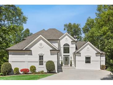 A beautifully landscaped home featuring a white exterior with a well-manicured lawn and mature trees at 900 Crossfire Nw Rdg, Marietta, GA 30064