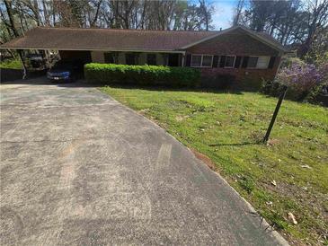 Cozy one-story brick home featuring well-maintained landscaping and a convenient carport at 2790 Hogan, East Point, GA 30344