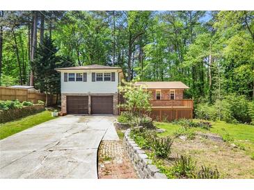 Charming home featuring a two-car garage and a spacious deck, nestled among mature trees at 2645 Davenport Rd, Duluth, GA 30096