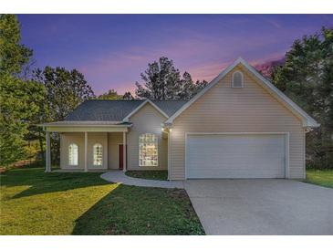 Charming single-story home with well-manicured lawn and attached two-car garage at dusk at 2505 Rockmart Rd, Villa Rica, GA 30180