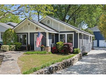 Charming single-story home featuring a well-manicured front yard with an American flag and stone accents at 1195 Oglethorpe Ne Ave, Atlanta, GA 30319