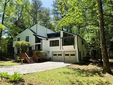 Stunning two-story home with white siding and a two-car garage nestled in a lush green landscape at 3312 Winter Wood Ct, Marietta, GA 30062