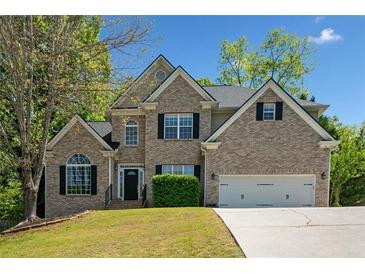 Charming two-story brick home featuring a well-manicured lawn and attached two car garage at 3338 Hackmatack Nw Dr, Kennesaw, GA 30152