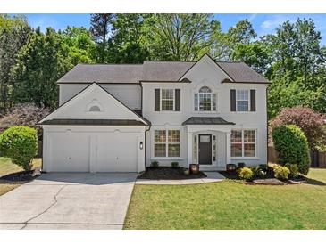 Charming two-story home with a two-car garage, landscaped front yard, and fresh, white exterior at 4680 Glen Level Dr, Sugar Hill, GA 30518