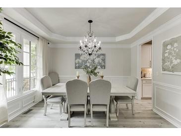 Elegant dining room features a decorative chandelier, table with seating, and large windows for lots of natural light at 7035 W Mountain Xing, Cumming, GA 30041