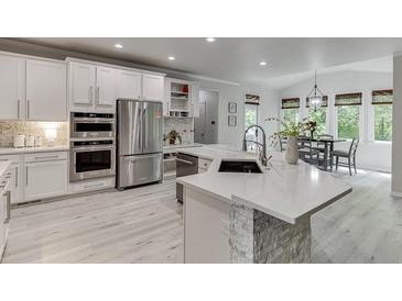 Beautiful kitchen featuring white cabinetry, stainless steel appliances, and a stylish island with stone accents at 7035 W Mountain Xing, Cumming, GA 30041