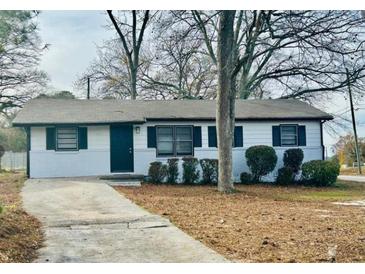 Charming single-story home with white siding, black shutters, and a well-manicured front yard at 2961 Stone Mountain St, Lithonia, GA 30058