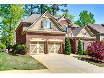 Charming two-story brick home with a well-manicured lawn, two-car garage and beautiful landscaping at 4125 Barnes Meadow Sw Rd, Smyrna, GA 30082