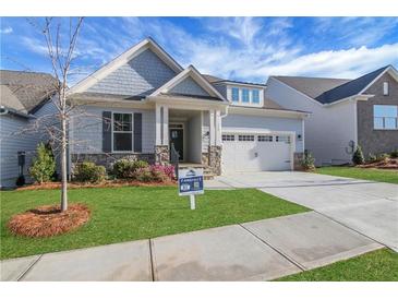 Charming home featuring manicured lawn, stone accents, attached two car garage and inviting entryway at 159 Sunshower Rdg, Canton, GA 30114