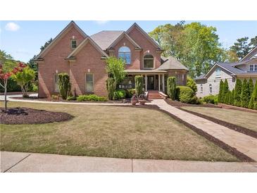 Charming brick home features a well-manicured lawn and meticulously maintained landscaping at 4030 Palisades Main Nw, Kennesaw, GA 30144