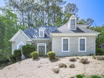 Charming single-Gathering home featuring stone accents and a well-maintained yard with mature trees at 1017 Fairway Valley Dr, Woodstock, GA 30189