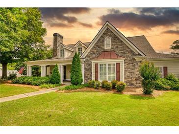 Charming stone and siding home with well-manicured lawn and mature landscaping at 3818 Bay Forest Way, Loganville, GA 30052
