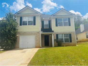 Charming two-story home with a well-manicured lawn and attached garage at 4884 Browns Mill Ferry Rd, Lithonia, GA 30038