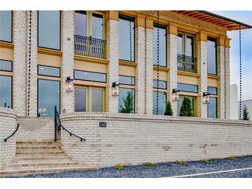 Stunning two-story brick home featuring expansive windows, stylish lighting, and charming wrought iron balconies at 140 Rolison Way, Fayetteville, GA 30214