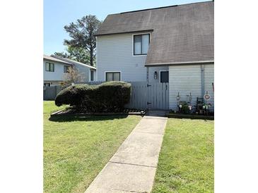 Charming townhome with a well-maintained lawn, mature bushes, and a gray privacy fence at 296 Country Club Dr, Jonesboro, GA 30238