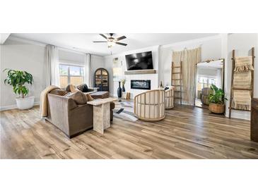 Bright living room featuring hardwood floors, a ceiling fan, and modern furniture at 3020 Westgate Park Dr, Loganville, GA 30052