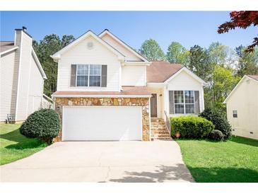 Charming two-story home featuring stone accents, a two-car garage, and a well-manicured lawn at 4032 Robin Cir, College Park, GA 30349