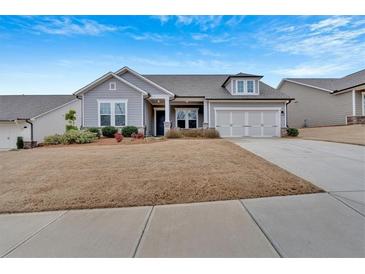 Charming single-Gathering home with attached two-car garage and manicured lawn under a bright blue sky at 242 Cordova St, Woodstock, GA 30189