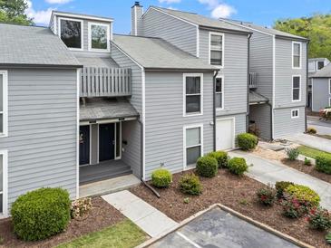 Inviting townhome with gray siding, manicured landscaping, and parking space at 1021 Riverbend Club Se Dr, Atlanta, GA 30339