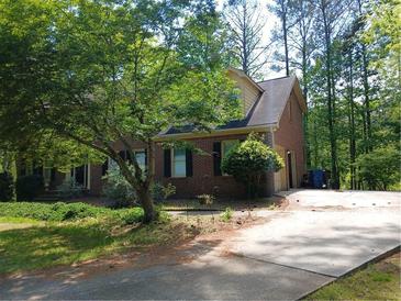 Cozy brick home with mature trees, inviting front lawn, and long driveway at 921 Eagle Crossing Dr, Lawrenceville, GA 30044