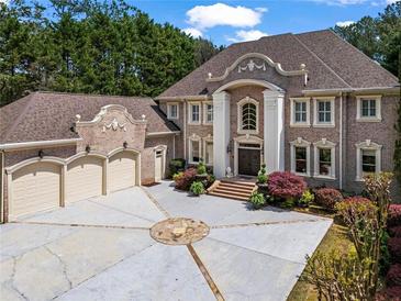 Stately brick home featuring meticulously manicured landscaping and a circular driveway at 2120 Blackheath Trce, Alpharetta, GA 30005