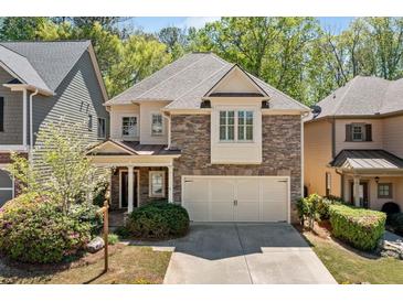 Charming two-story home featuring a stone facade, well-manicured landscaping, and a spacious two car garage at 8215 Majors Mill Dr, Cumming, GA 30041