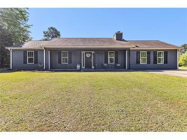 Charming single-story home with a well-manicured lawn and cozy front porch seating at 95 Graystone Dr, Covington, GA 30014
