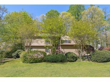 Charming two-story home with a lawn and mature landscaping surrounded by trees providing shade and privacy at 1735 Little Willeo Rd, Marietta, GA 30068