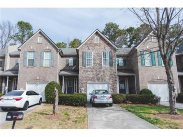 Charming townhouse with stone and brick facade, attached garages, and well-maintained landscaping at 275 Fern Crest Dr, Lawrenceville, GA 30046