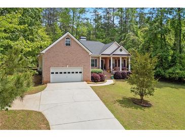 Charming brick home featuring a columned front porch and a well-manicured lawn at 5071 Woodmont Dr, Villa Rica, GA 30180