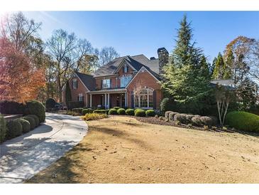 Impressive brick home with mature landscaping and a circular driveway at 13230 Addison Rd, Roswell, GA 30075