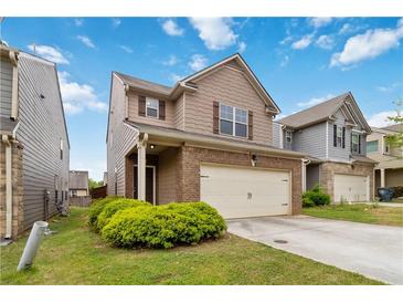 Charming two-story home featuring a brick and neutral toned facade, a two-car garage, and a well-maintained lawn at 5885 San Gabriel Ln, Atlanta, GA 30349