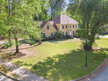 Inviting two-story home with a well-manicured lawn and mature trees surrounding the property at 7389 Tidewater Trce, Stone Mountain, GA 30087