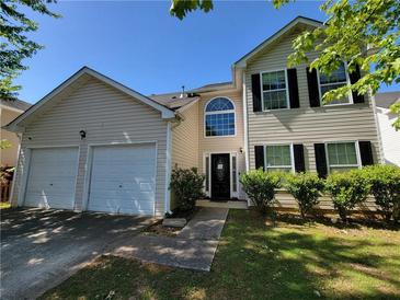 Two-story home with attached two-car garage and manicured lawn under a clear, blue sky at 2752 Live Oak Trl, Atlanta, GA 30349