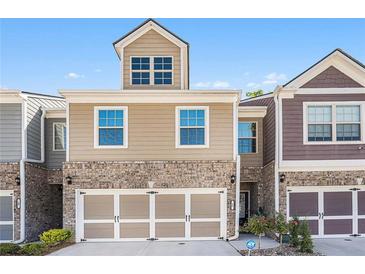 Charming townhome featuring a two-car garage, brick accents, and a neatly maintained front lawn at 38 Trailview Ln, Hiram, GA 30141