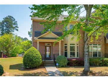 Charming two-story brick home with manicured lawn and covered front porch at 6150 Thorncrest Dr, Tucker, GA 30084