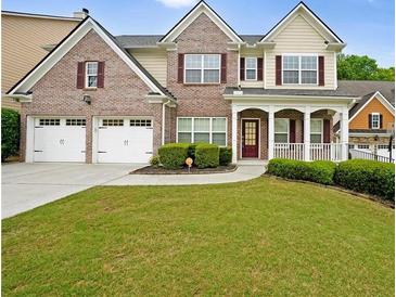 Charming two-story brick home with well-manicured lawn, a two-car garage and inviting front porch at 841 Sapphire Ln, Sugar Hill, GA 30518