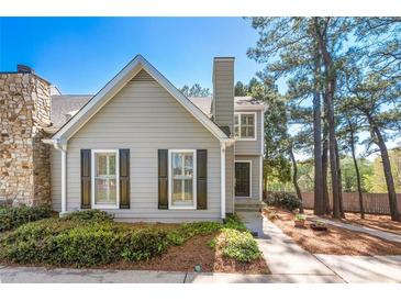 Charming home with a landscaped front yard, featuring a stone accent wall and fresh, neutral paint at 1214 Defoors Nw Ct # 1A, Atlanta, GA 30318